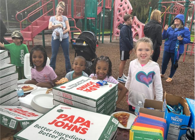 Estudiantes comiendo pizza en el parque imagen