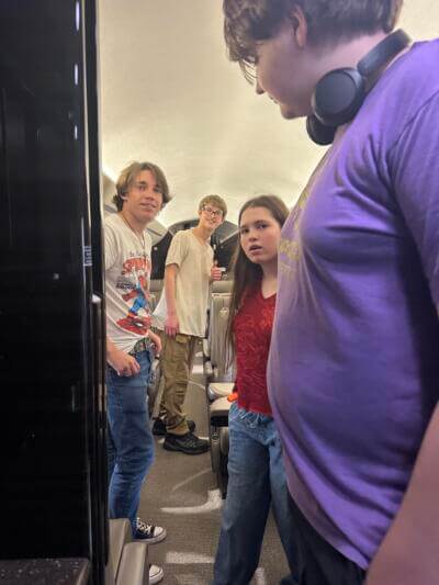 Cuatro jóvenes en el pasillo de un avión.