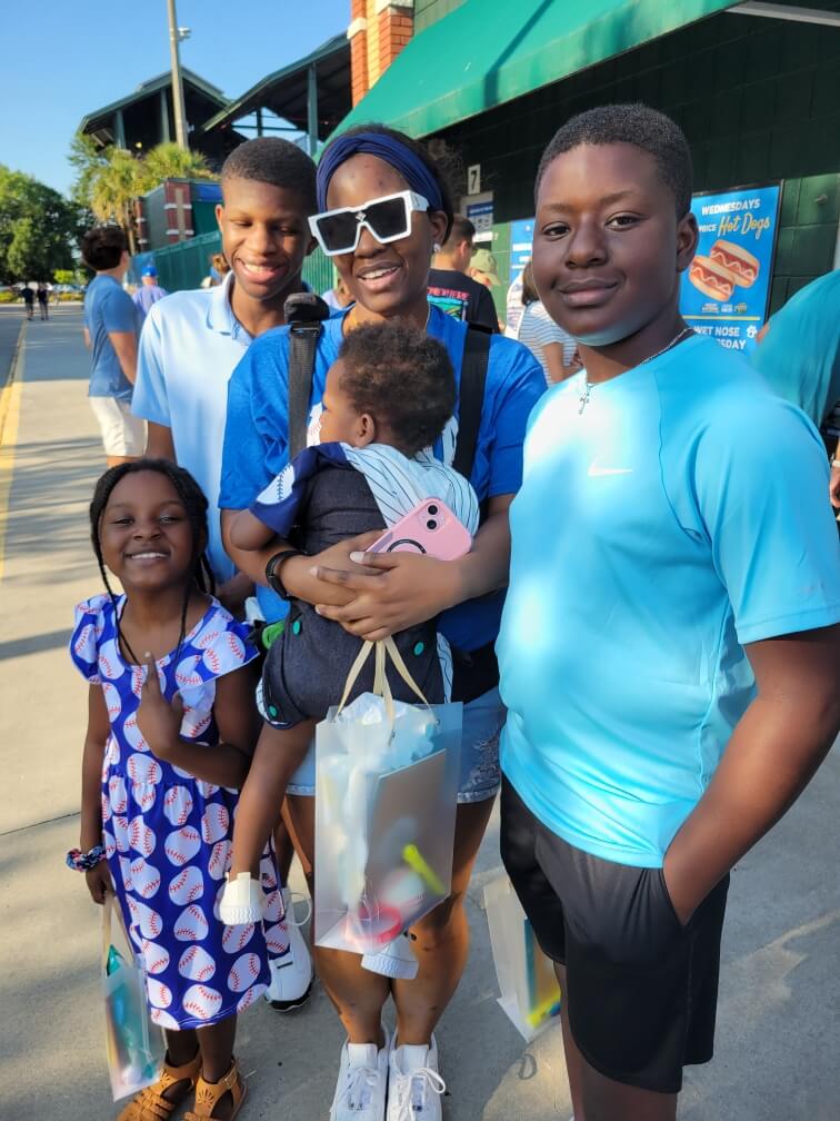 Una familia sonriente disfruta de un día soleado en un estadio.