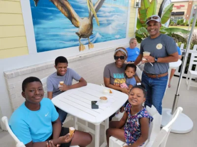 Cuatro niños y dos adultos comiendo helado