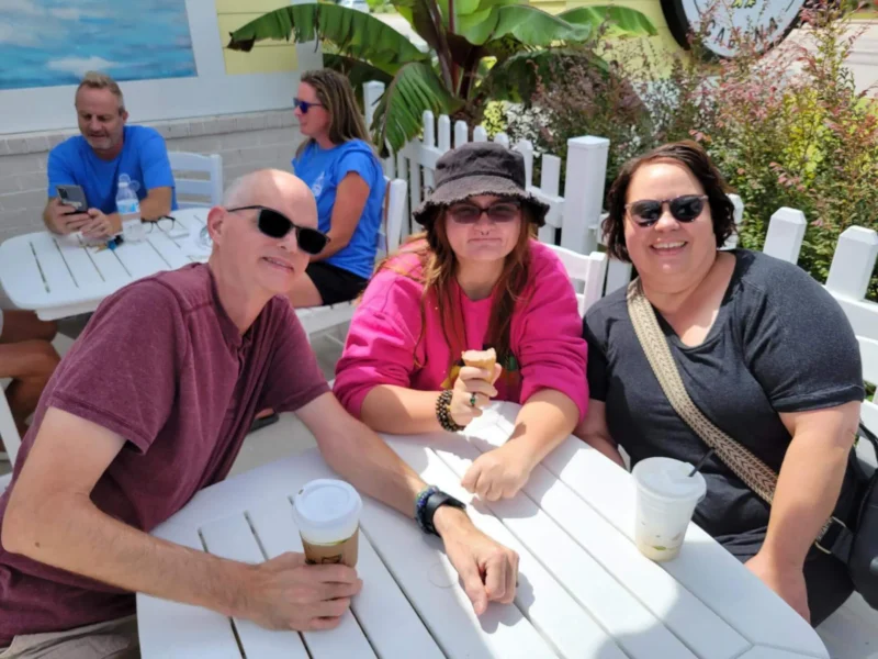Tres personas tomando café al aire libre
