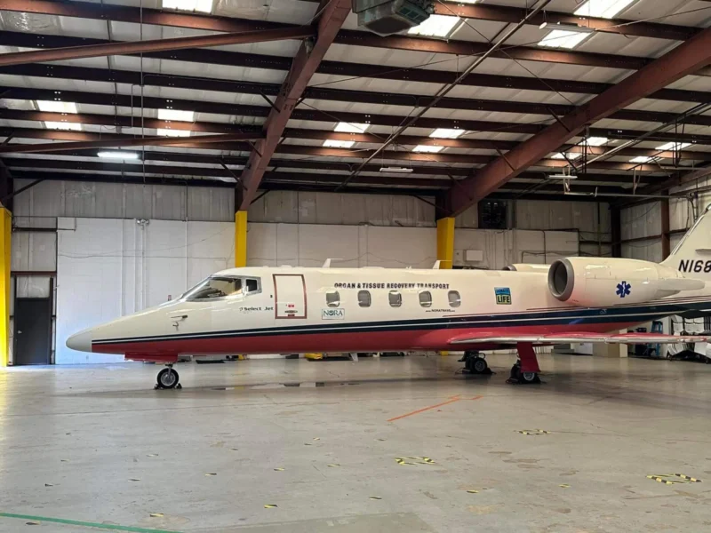 Jet privado en un hangar espacioso, rotulado "Transporte de órganos y tejidos".