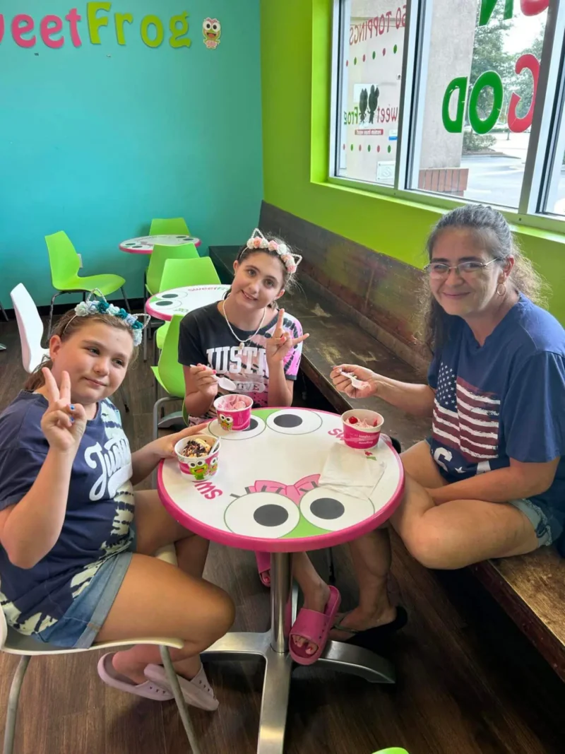 Tres personas sentadas en una colorida mesa Sweet Frog