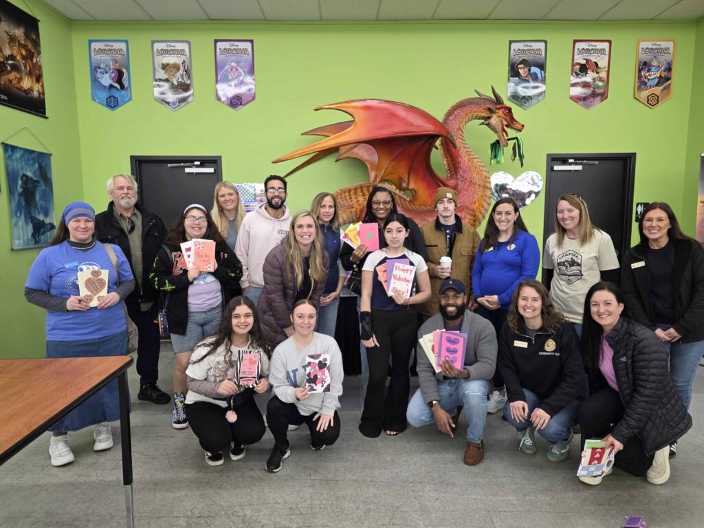 Un grupo de personas sonriendo delante de una pared verde